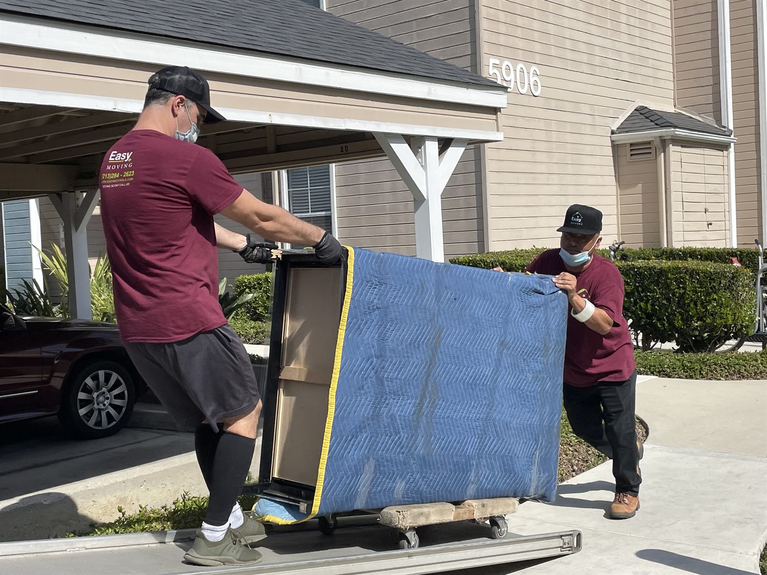 Movers protecting furniture with a moving blanket